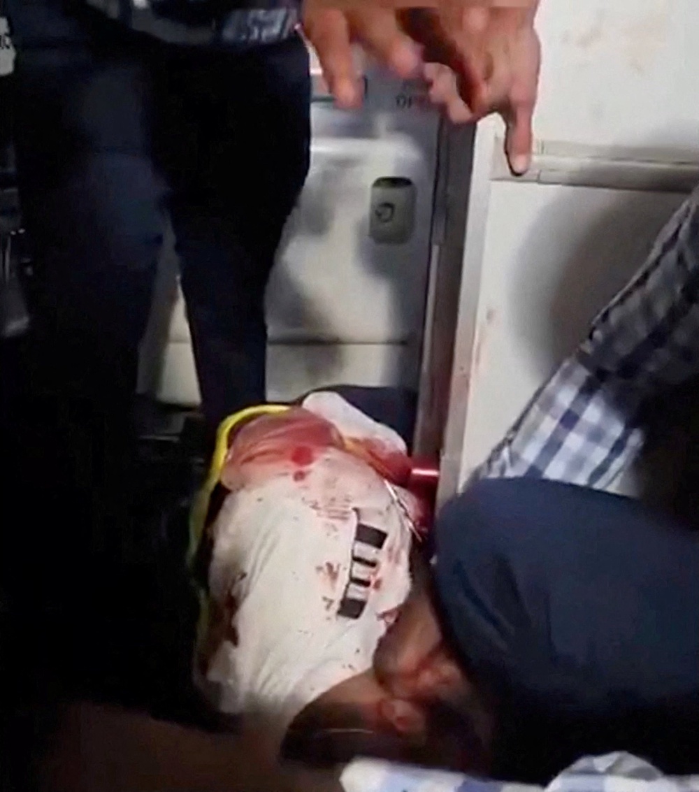 Passengers gather around an injured man aboard a Tel-Aviv-bound flydubai plane which was forced to land in Saudi Arabia after the pilots reportedly fought in the cockpit (Reuters)