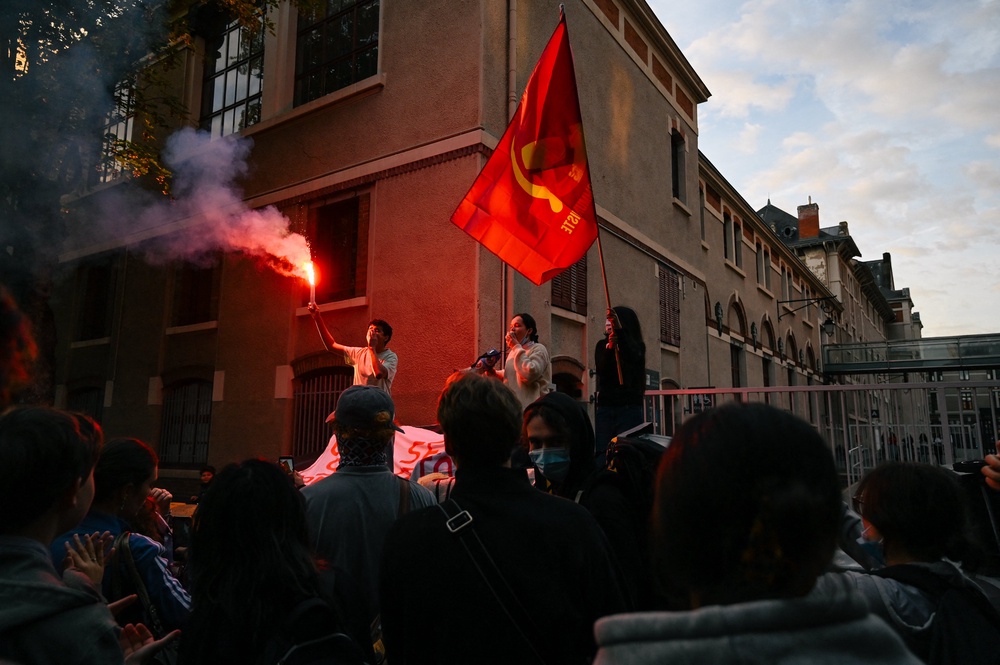 High school students speak on bins and light a smoke torch in front of Jeanne d’Arc high school in Clermont-Ferrand (AFP/Getty)