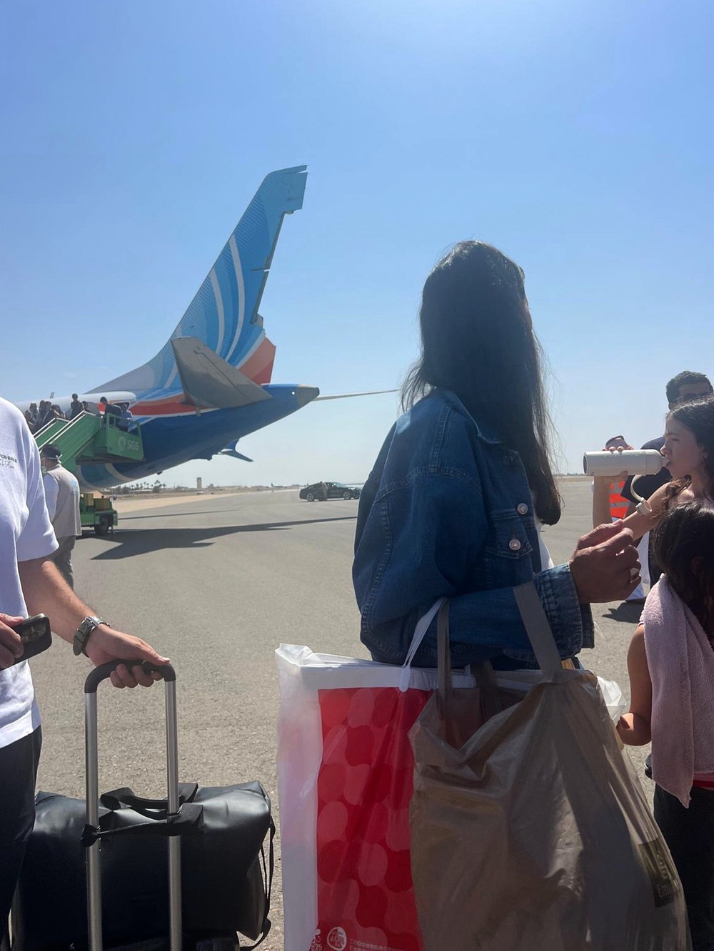 Passengers stand beside Flydubai Flight FZ1073, with damage visible to the aircraft's tail, after it made an emergency landing at Prince Sultan bin Abdulaziz International Airport in Tabuk, Saudi Arabia, Wednesday, Sept. 30, 2026 (AP)
