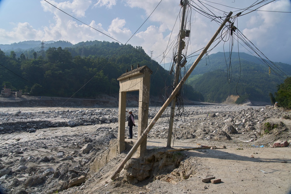 A man stands next to the damaged gate by flash flood (AP)
