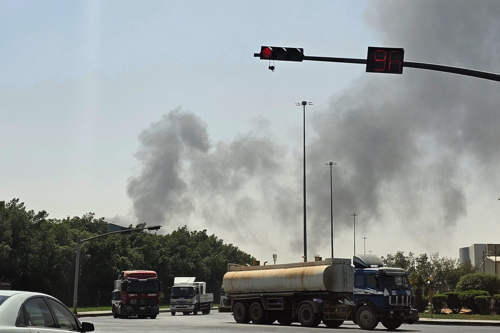 Vehicles travel along a road as black smoke billows from a fire at an oil facility in an industrial area in southern Riyadh, Saudi Arabia, Saturday, Oct. 3, 2026. (AP)
