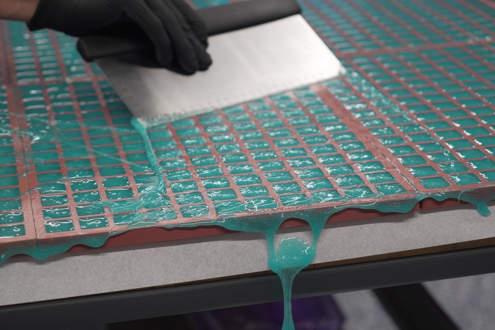 Hot gummy mixture drips off the table's edge as Nicholas Hohns uses a pastry knife to fill mold at his Deutermann Farms kitchen in Clayton, N.C., on Wednesday, Sept. 23, 2026. (AP Photo/Allen G. Breed) (Copyright 2026 The Associated Press. All rights reserved)