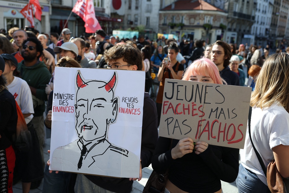 Students hold a placard which reads as 'Finance Minister, review your finances' (L) and 'Angry young people, but not fascists' (R), during a gathering amid a nationwide protest movement over school conditions in Saint-Denis, north of Paris, on October 4, 2026 (AFP/Getty)