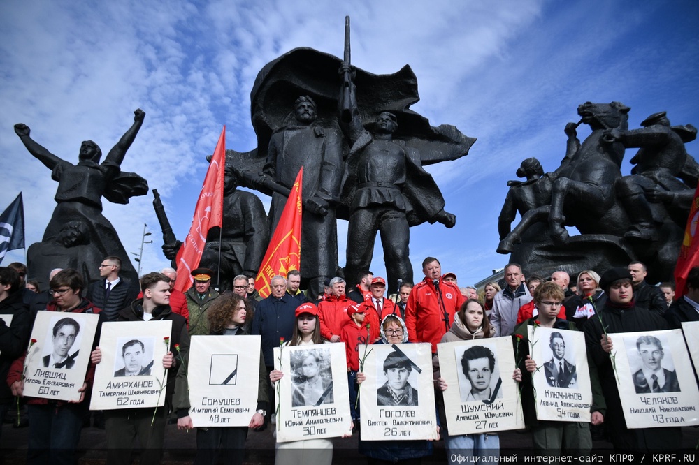 People with flowers and portraits of those who were killed during the 1993 bloody clashes between government forces and supporters of the rebellious parliament gather to rally marking the 33rd anniversary of the events in front of the Monument to the heroes of the Revolution of 1905, in Moscow, on Sunday, Oct. 4, 2026 (AP)