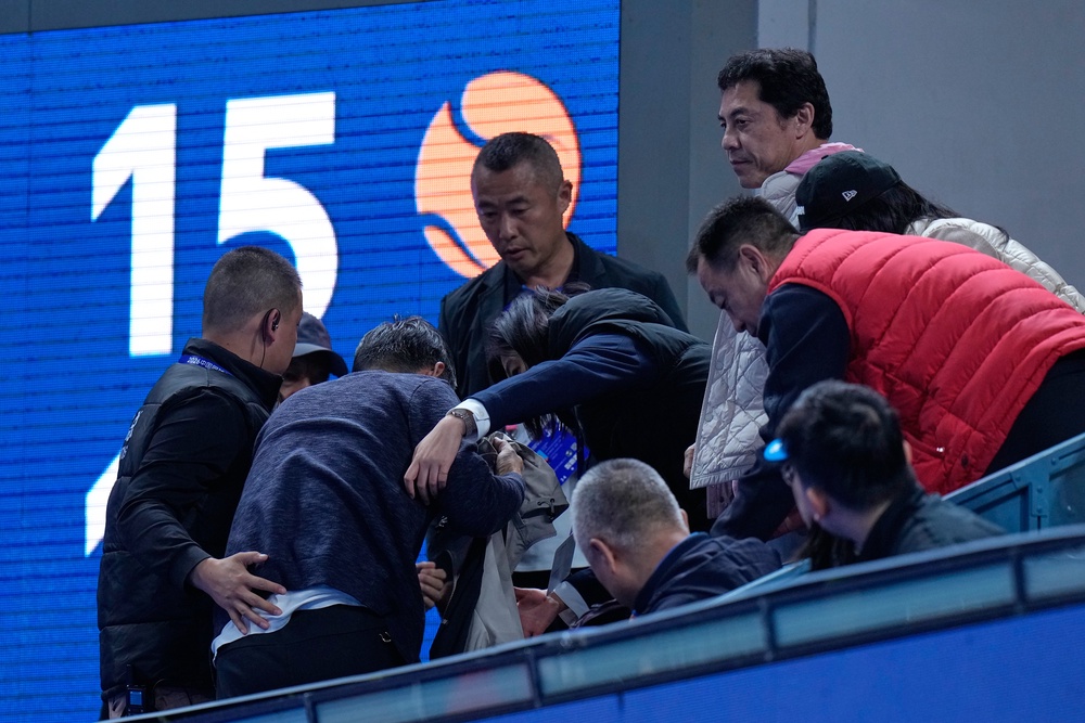 China Open officials assist a spectator injured by a ball hit into the stands by Medvedev (Andy Wong/AP) (AP)