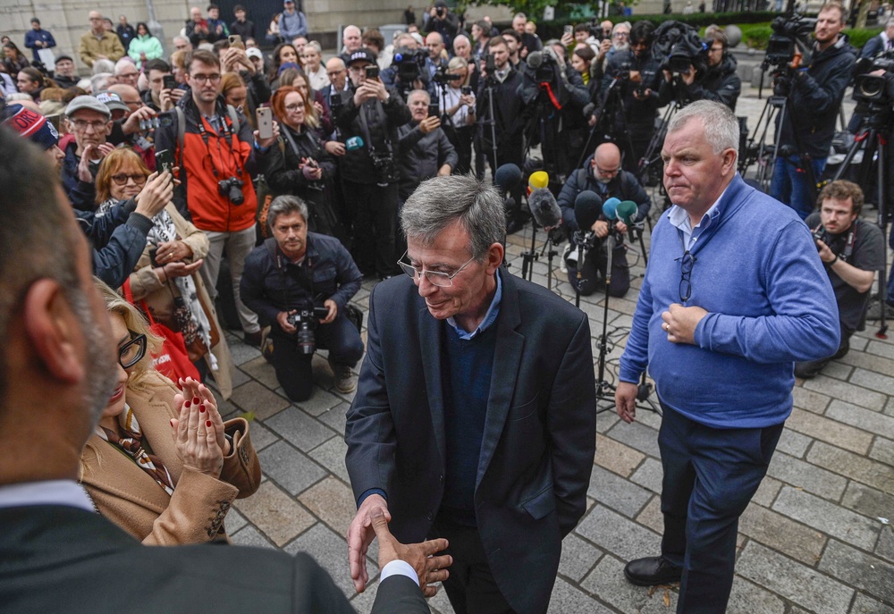 Breandan Mac Cionnaith (Brendan McKenna, centre), and members of the Garvaghy Road Residents coalition outside the High Court in Belfast (Mark Marlow/PA) (PA Wire)