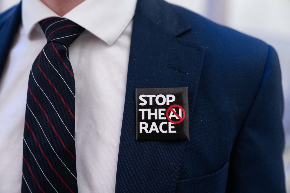 A person wears a 'Stop the AI Race' badge outside of a New York City Council Committee hearing (Getty)