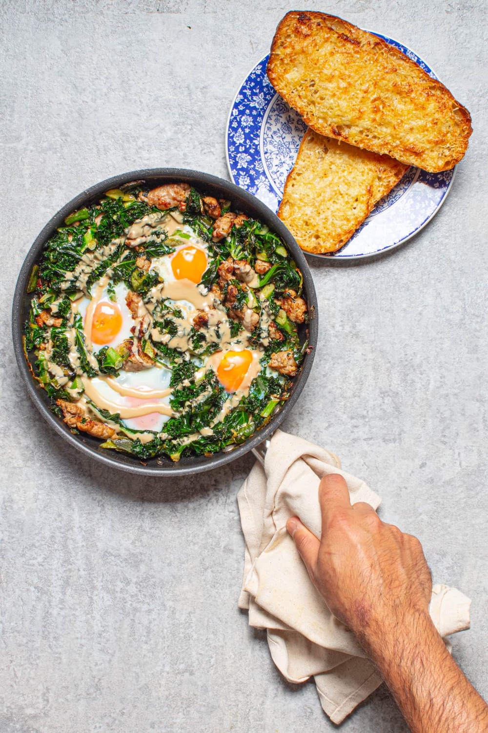Sausage and kale baked eggs with tahini and crisp, cheesy garlic ciabatta (Sorted Food)