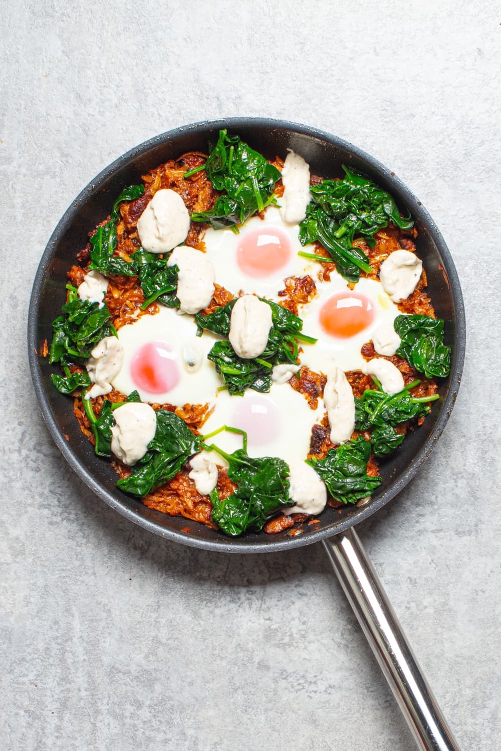 Crisp potato and sausage hash topped with baked eggs, wilted spinach and garlicky aioli (Sorted Food)