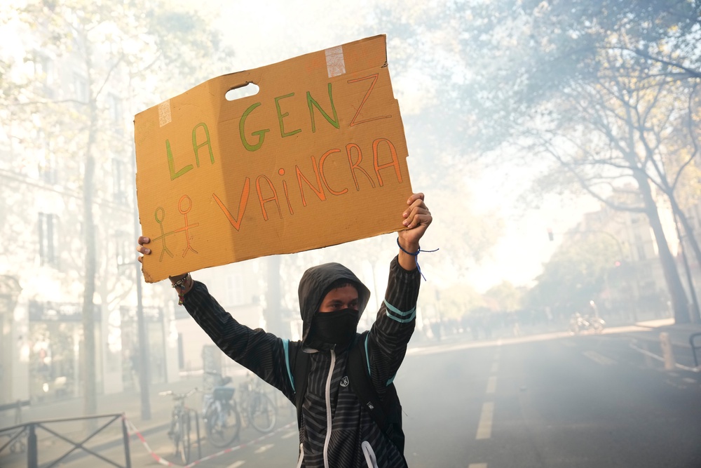 A student holds a sign reading 'GenZ will win' during a protest against under-resourced schools, in Paris (AP)