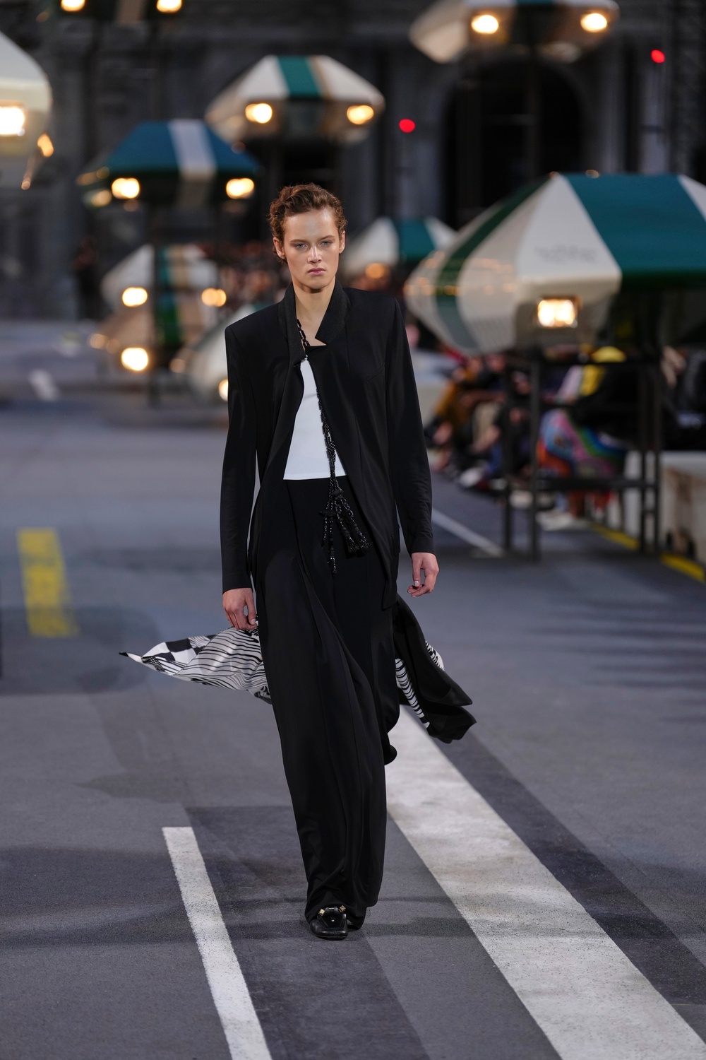 The closing look featured a simple black lightweight suit with a silk scarf trailing behind (Aurelien Morissard/AP) (AP)