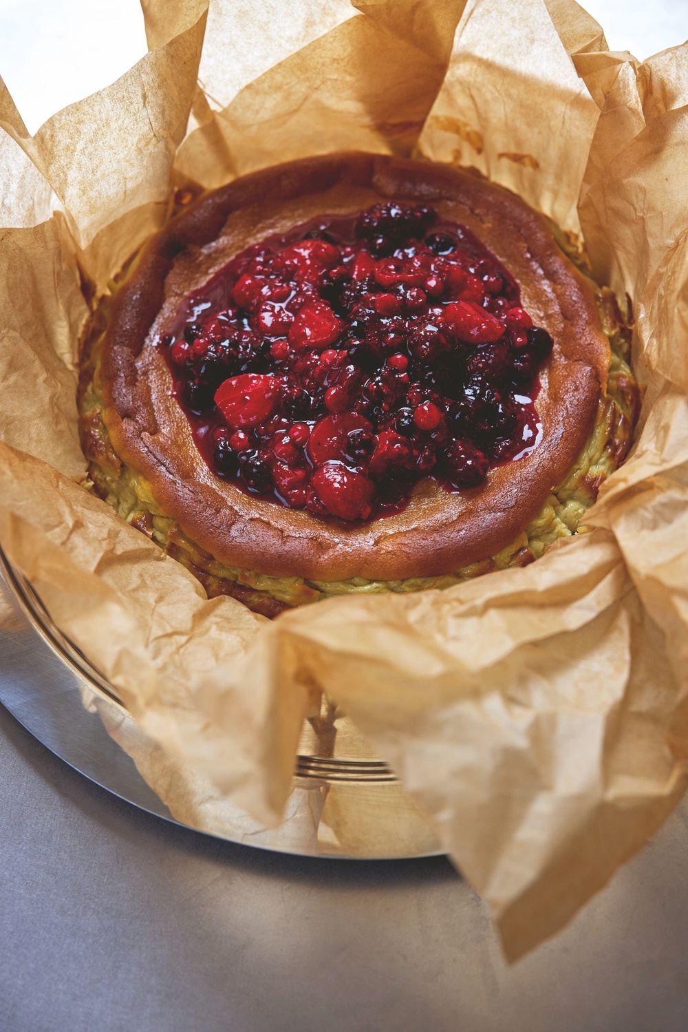 Bhogal’s pistachio Basque cheesecake is served with a roasted berry compote (Matt Russell)