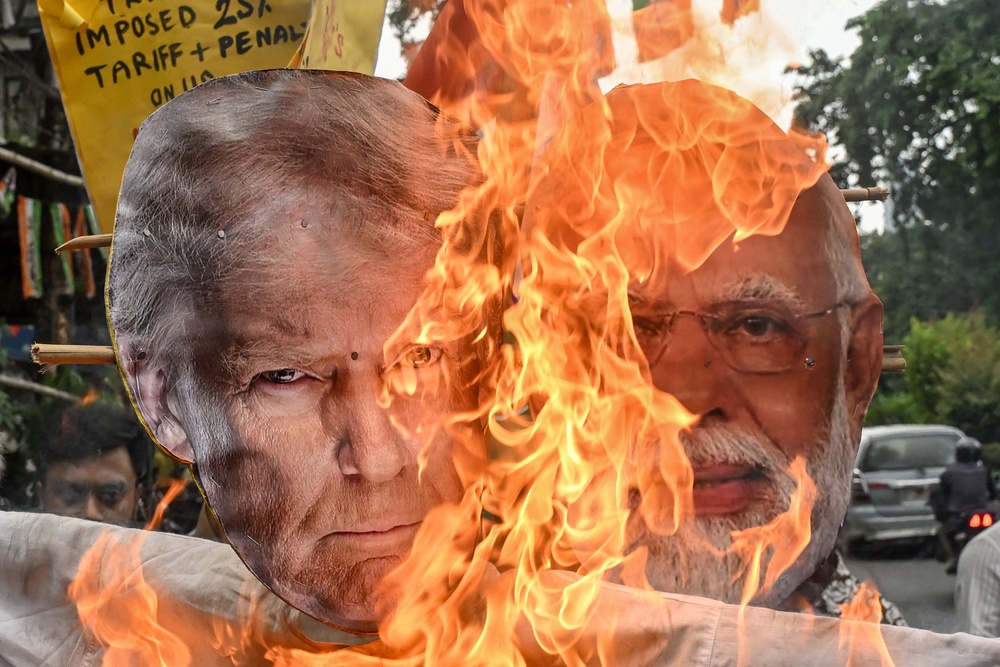 Supporters of the opposition Congress party burn an effigy of US president Donald Trump and Indian prime minister Narendra Modi during a protest against the Indo-US trade deal in Kolkata on 1 August 2025 (AFP/Getty)