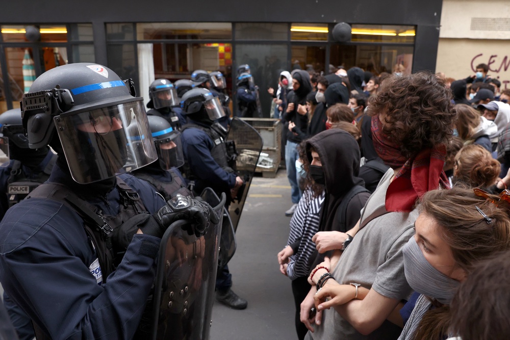 Police watch over students as they demonstrate during a protest over school overcrowding and decay on 7 October in Paris, France (Getty)