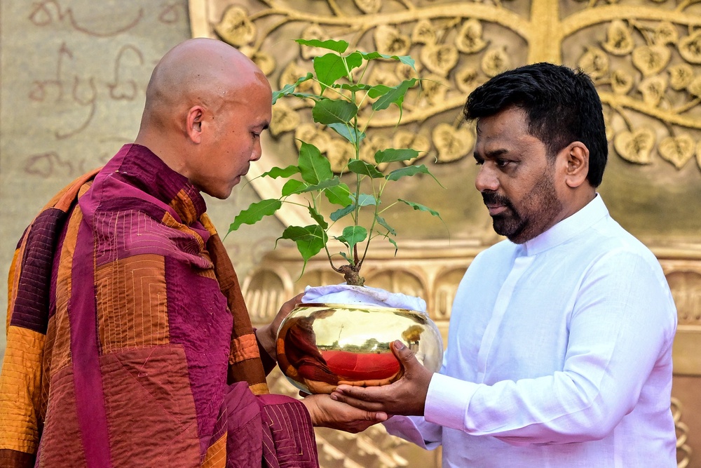 Sri Lankan president Anura Kumara Dissanayake gives a sapling to a Vietnamese Buddhist monk in Colombo on 18 April 2026 (AFP/Getty)