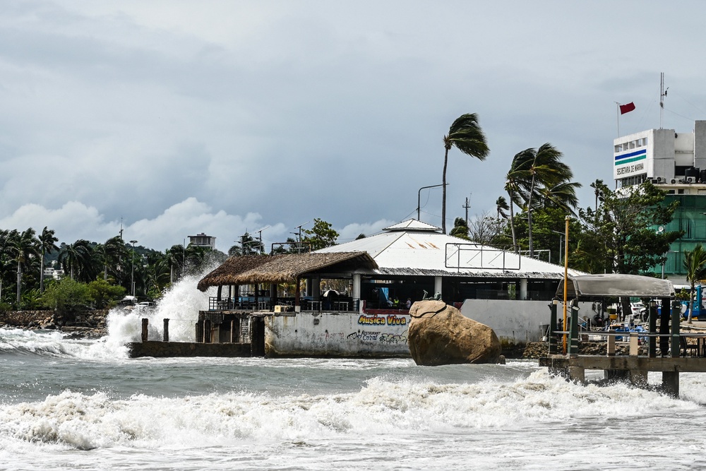 High waves crash against the waterfront as a red warning flag (R) flies outside the port captain's office in the tourist port of Acapulco, Guerrero state, Mexico (AFP/Getty)