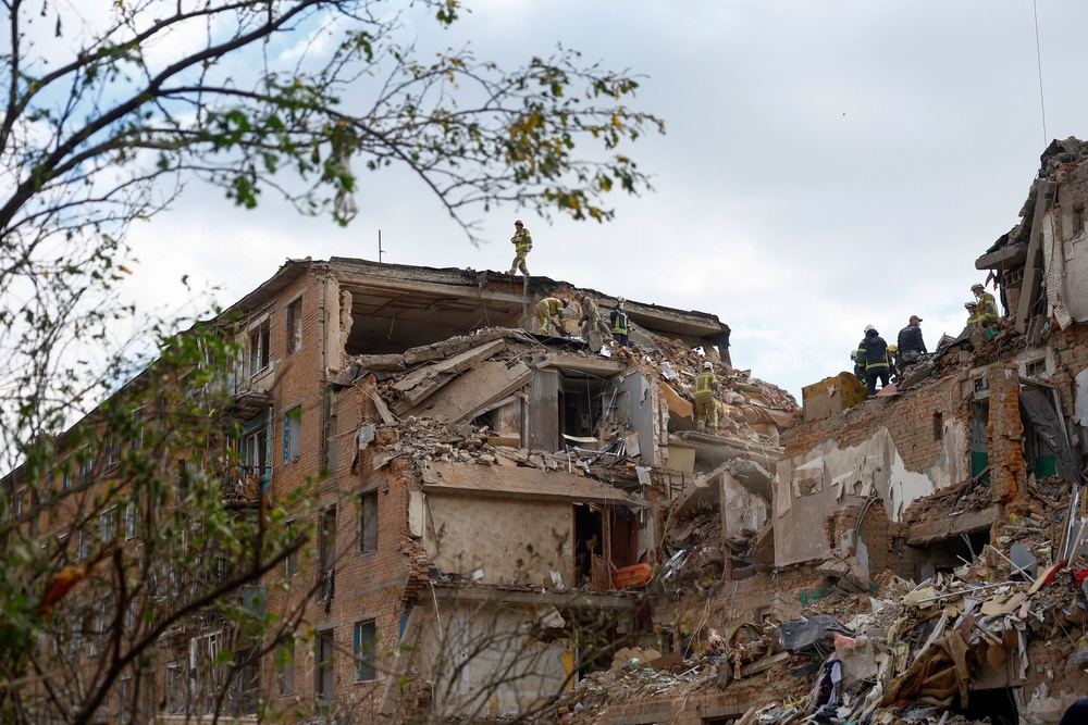 Rescuers work at the site of an apartment building which was hit by a Russian missile strike (Reuters)