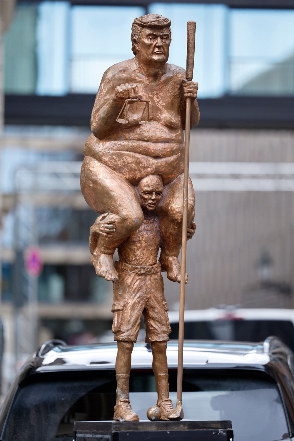 Showing him naked and balanced atop a far smaller man, the statue labels the US president “The King of Injustice” (Getty)