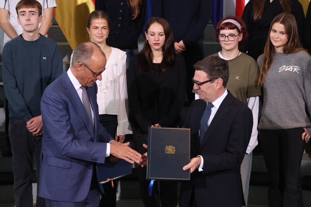 German Chancellor Friedrich Merz and British Prime Minister Andy Burnham exchange ratification documents of the Kensington Treaty (Getty)