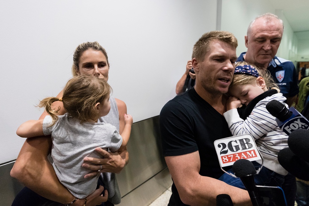 David Warner and his family are met by waiting press at Sydney Airport (Getty)