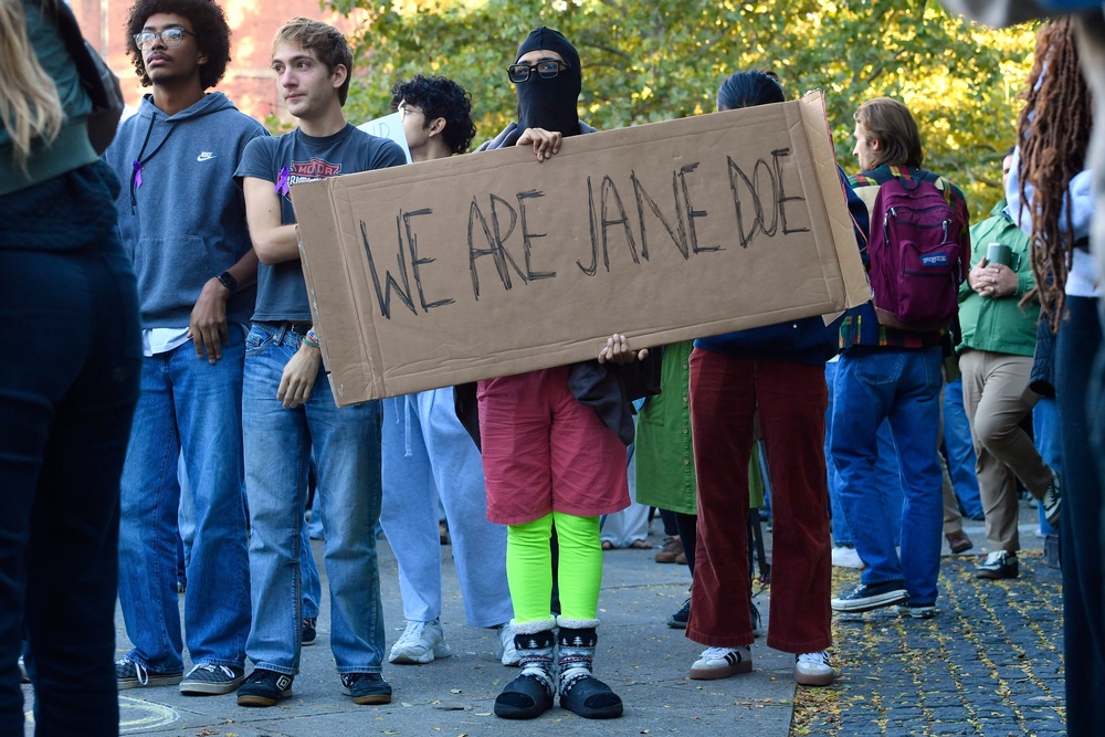 A demonstrator holds a sign reading 