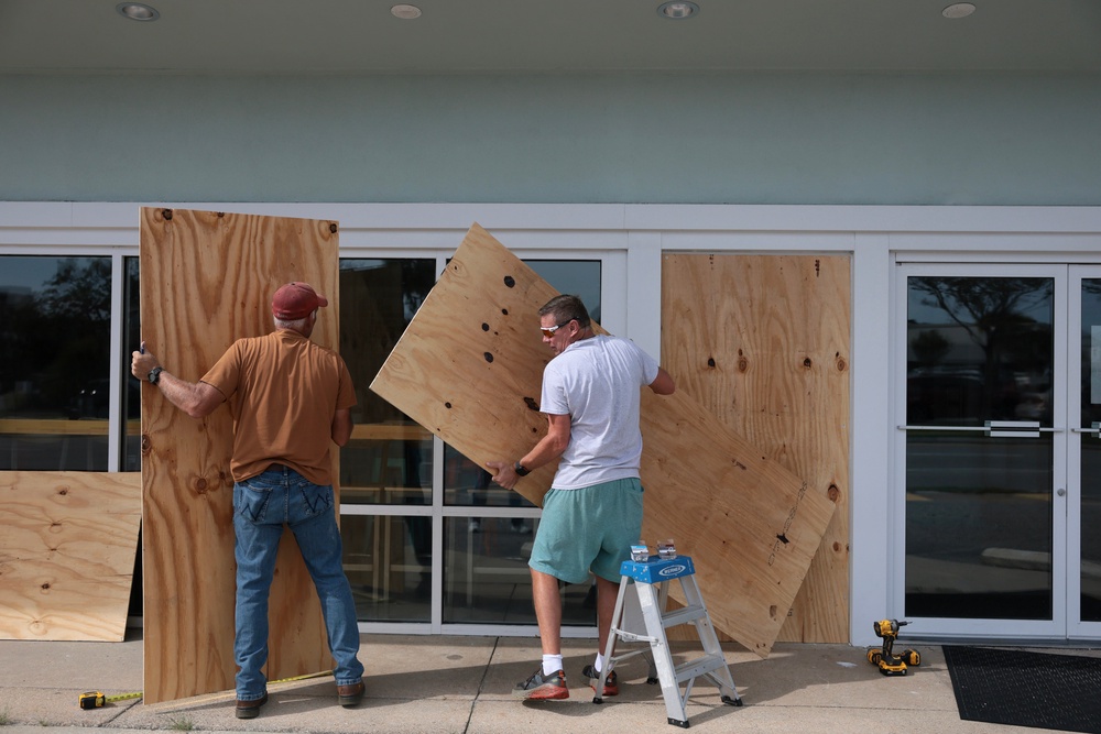 David Schisler and Courtney Head place plywood over the windows of the Islander Ice Cream restaurant as they prepare for the possible arrival of Hurricane Isaias (Getty)