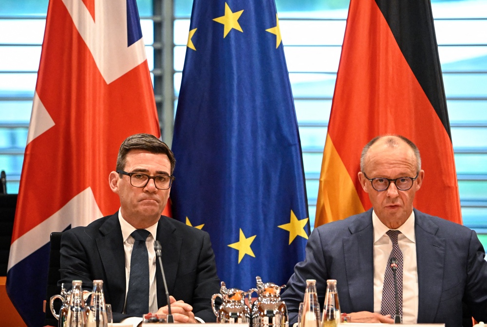 Andy Burnham and German chancellor Friedrich Merz take part in a business forum at the Chancellery in Berlin on 8 October 2026 (AFP/Getty)