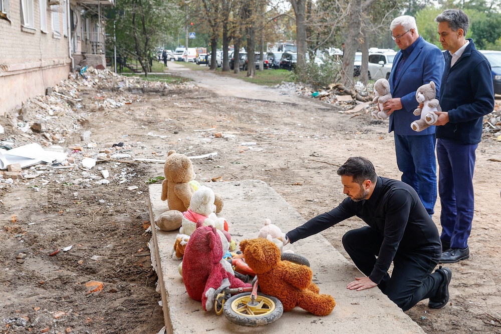 British Foreign Secretary Ed Miliband, Ukraine's President Volodymyr Zelenskiy and Foreign Minister Andrii Sybiha visit a makeshift memorial at the site of an apartment building where 22 residents were killed yesterday by a Russian missile strike in the town of Pryluky, amid Russia's attack on Ukraine, in the Chernihiv region, Ukraine (Reuters)