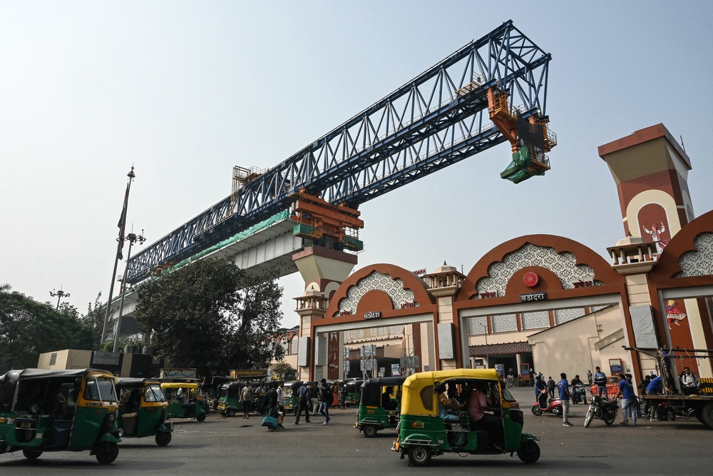 File. Auto-rickshaw drivers ride past a construction site of the bullet train project ‘Mumbai-Ahmedabad High Speed Rail corridor’ in Vadodara on 4 February 2026 (AFP/Getty)