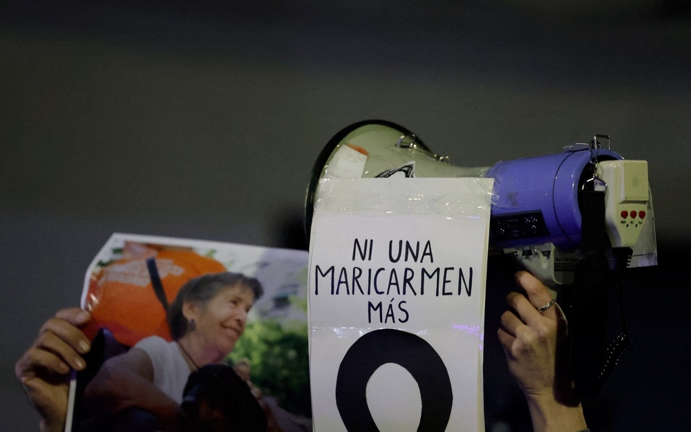 A demonstrator carries a picture of the late Maricarmen Abascal and a sign reading ‘not one Maricarmen more’, in Madrid, on Thursday (Reuters)