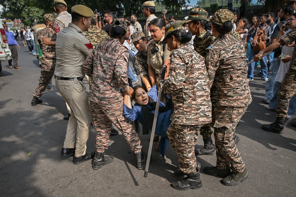 Police detain a protester during a demonstration in Delhi on Saturday (Getty)