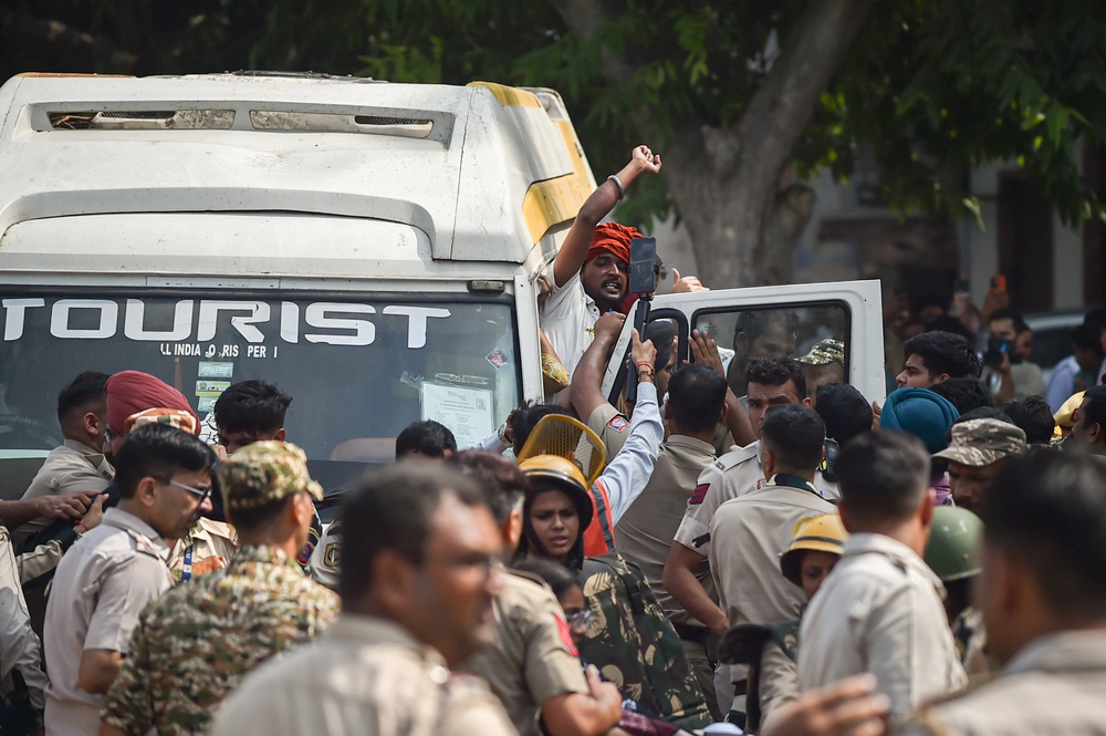 Police officers detain a protester during a demonstration in Delhi on Saturday (Getty)