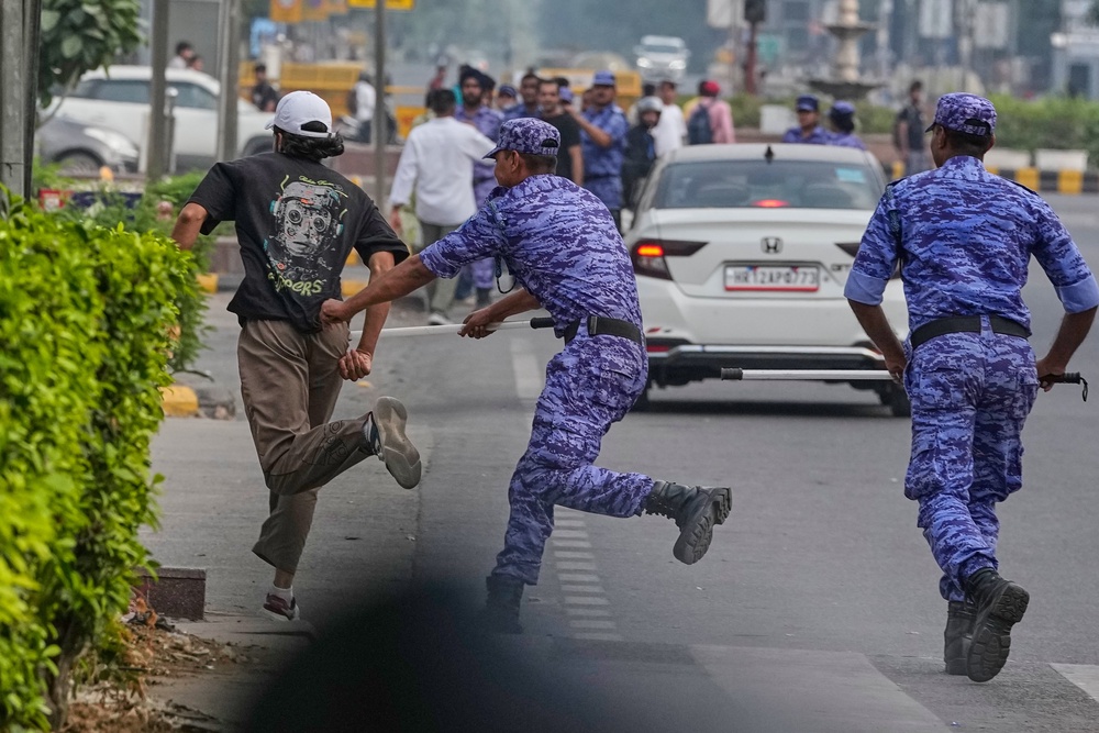 Security personnel detain a protester in Delhi on Saturday (AP)