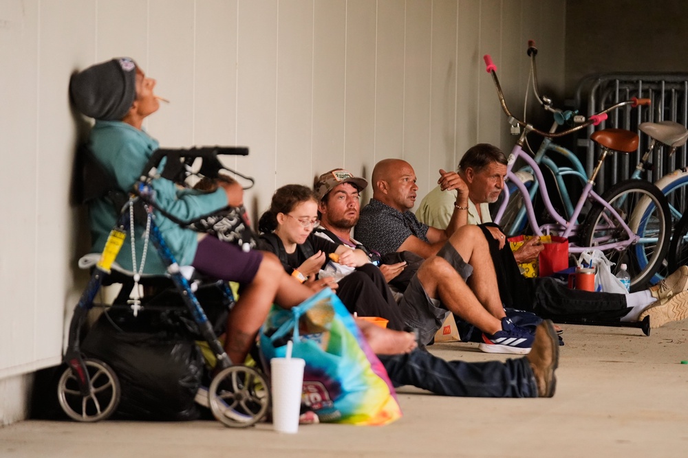 People sit outside an evacuation shelter as Hurricane Isaias approaches Pensacola, Fla., Friday, Oct. 9, 2026 (AP Photo/Gerald Herbert)