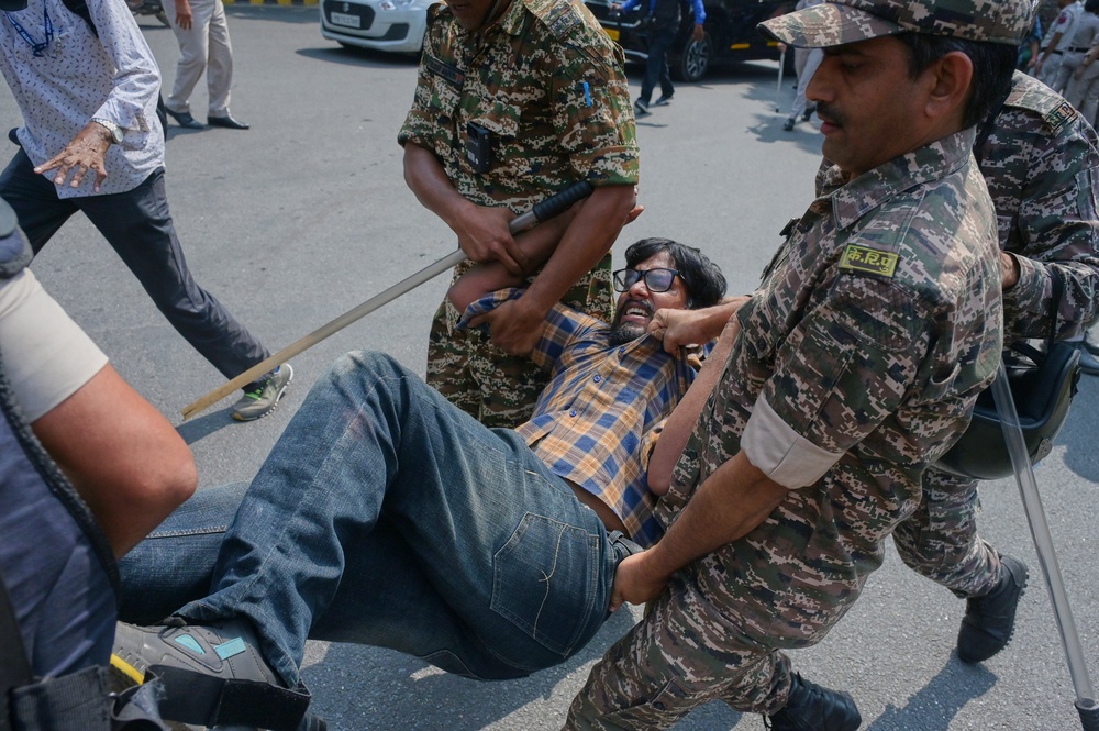Security personnel detain a protester in Delhi on Saturday (AP)