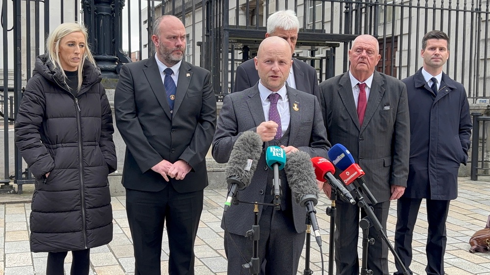 Loyalist activist Jamie Bryson speaks to media alongside leading members of the Portadown District of the Orange Order, DUP MP Carla Lockhart and MLA Jonathan Buckley outside the High Court in Belfast amid a legal challenge to a decision by Secretary of State Sir Chris Bryant to stop an Orange parade along the Garvaghy Road. (Rebecca Black/PA)