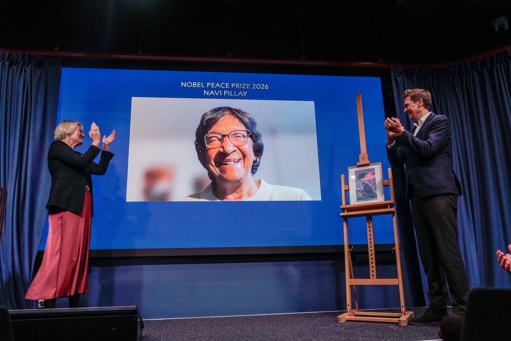 The Director of the Nobel Peace Center, Kjersti Flogstad, left, and the head of the Norwegian Nobel Committee, Jorgen Watne Frydnes, right, applaude as this year's Peace Prize laureate Navanethem Pillay is displayed via video link at the Nobel Peace Center in Oslo, Norway (AP)