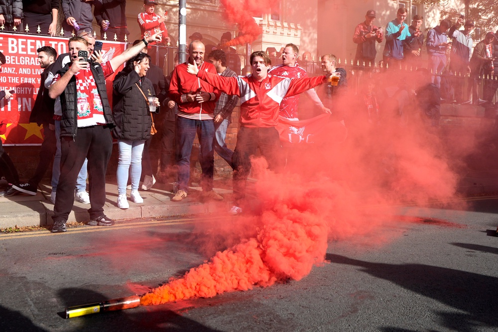 Liverpool fans set off flares as the Manchester City bus arrived at Anfield (PA)