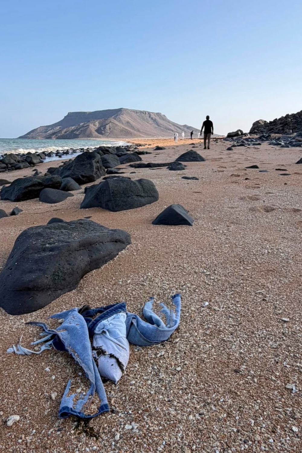 Personal items likely belonging to the migrants, including shoes, were seen on a beach in a video shared by IOM. (International Organization for Migration)