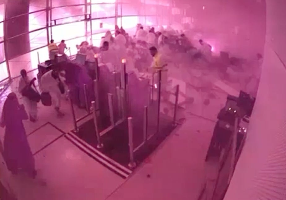 This image from CCTV video released by Saudi Arabia's Media Ministry shows passengers taking cover as flames and smoke fill part of King Khalid International Airport in Riyadh, Saudi Arabia, during what authorities described as a strike at the airport on Saturday, Oct. 10, 2026. (Saudi Media Ministry)