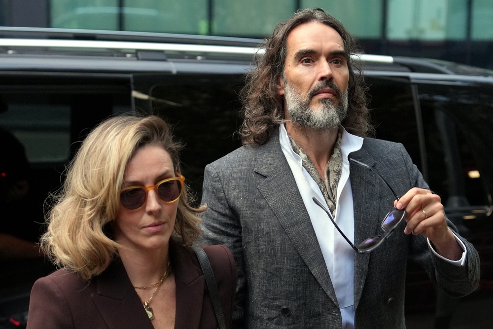 Brand pictured arriving with his wife Laura (AP)
