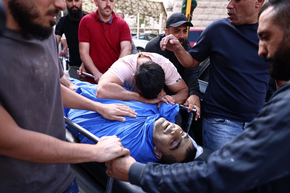 A son of Palestinian Ali al-Bazzari mourns as his body is carried at Rafidia Hospital in the Israeli-occupied West Bank city of Nablus, after he was reportedly killed in an Israeli settler and army raid in Burqa (AFP/Getty)