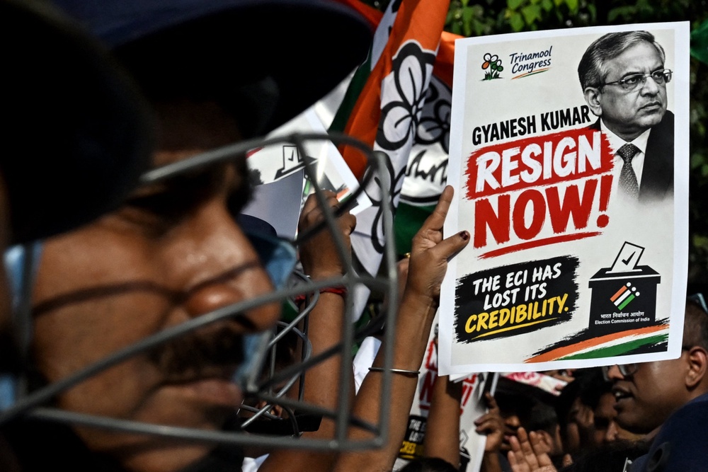 A protester carries a poster during a demonstration against chief election commissioner Gyanesh Kumar (AFP/Getty)