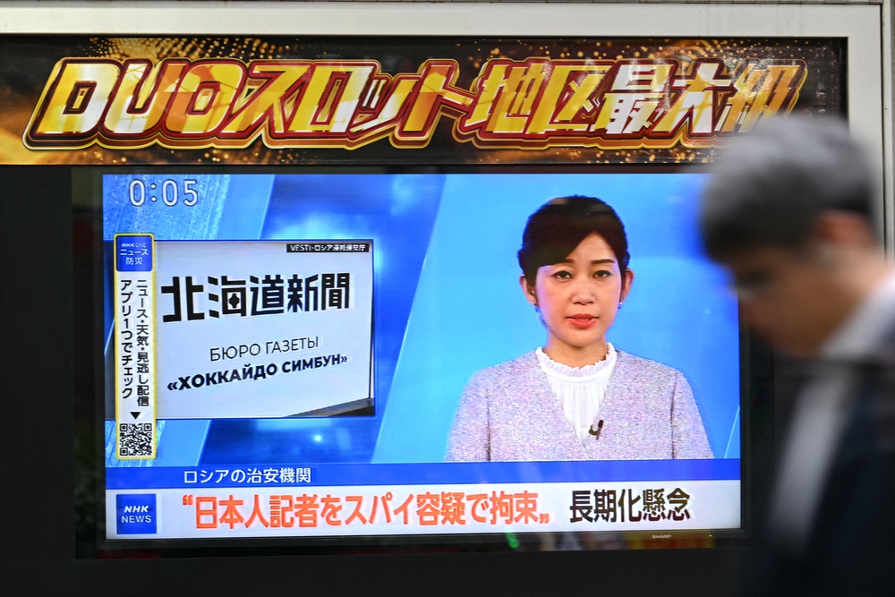 A man walks past a screen in Tokyo displaying a news broadcast about the arrest of Japanese reporter Yuki Imai (AFP/Getty)