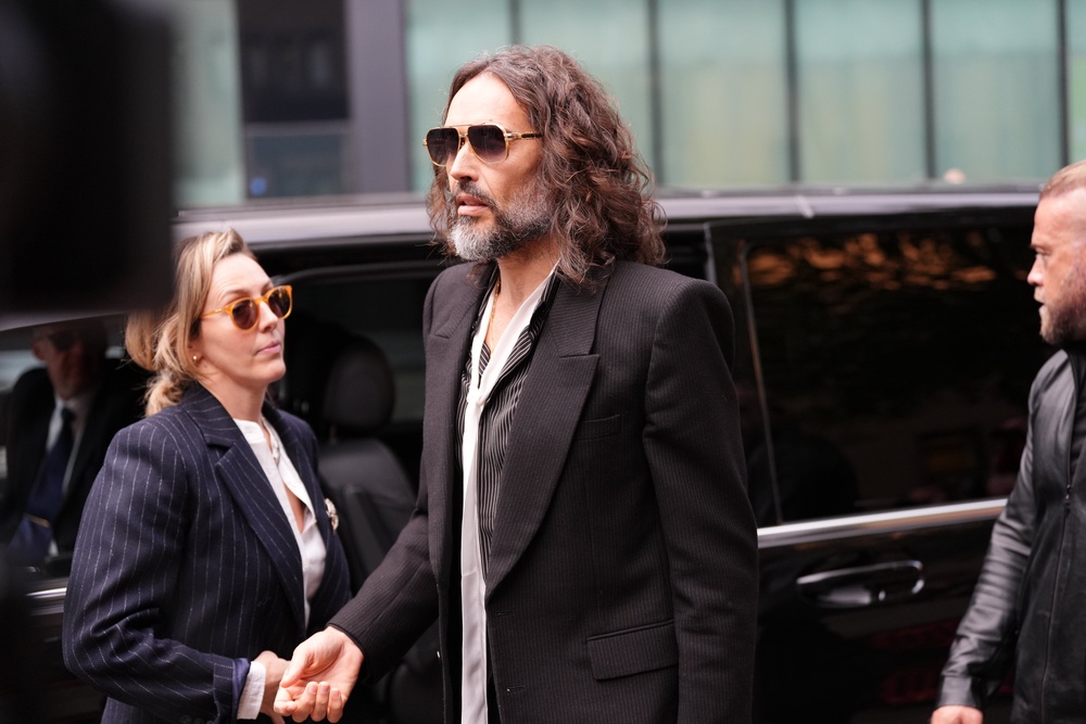 Russell Brand pictured with his wife outside court (PA)