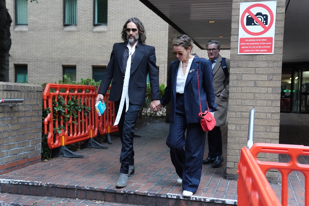 Russell Brand leaving Southwark Crown Court with his wife, Laura Gallacher (PA)