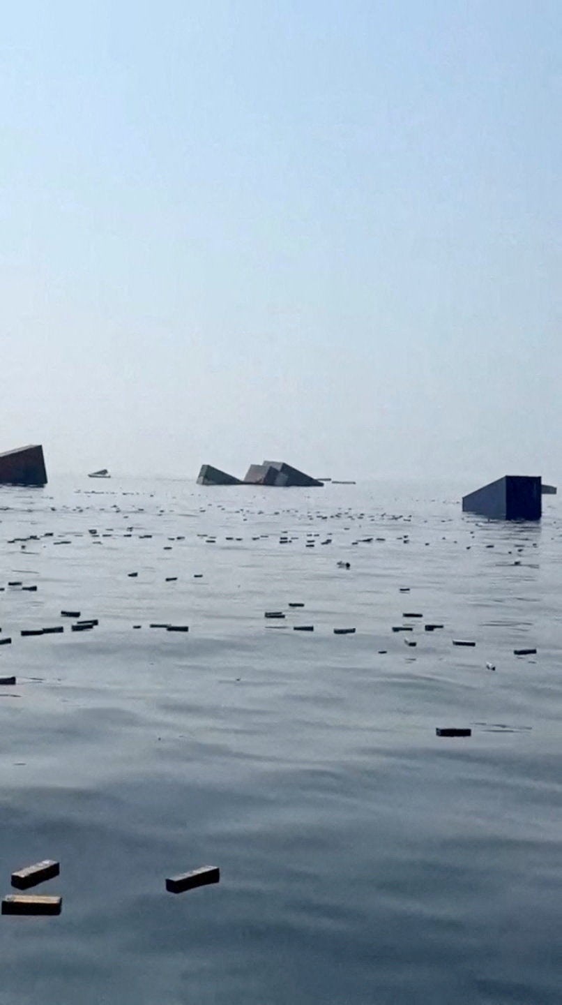 Containers and items float in the water a vessel sank near the Strait of Hormuz off the coast of Oman, in this still image obtained from a social media video, released October 14, 2026. (Social media)