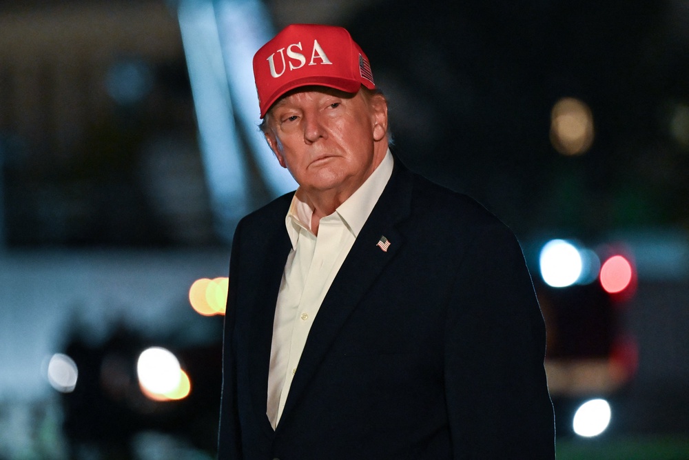 Donald Trump gestures after arriving on Marine One on the South Lawn at the White House in Washington, DC, in the early hours of October 15 (AFP/Getty)