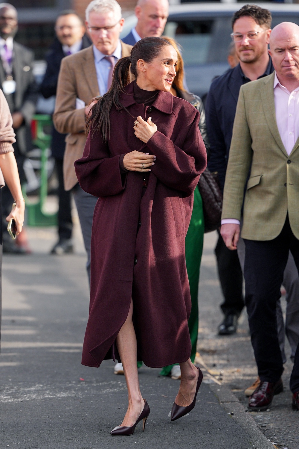 Meghan pictured arriving in a long burgundy coat (Getty)