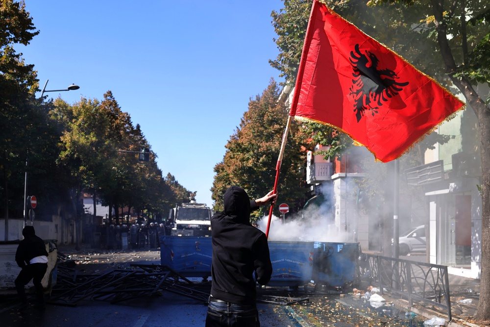 A protester on Wednesday waves an Albanian flag during clashes in Tirana, Albania. (AP)